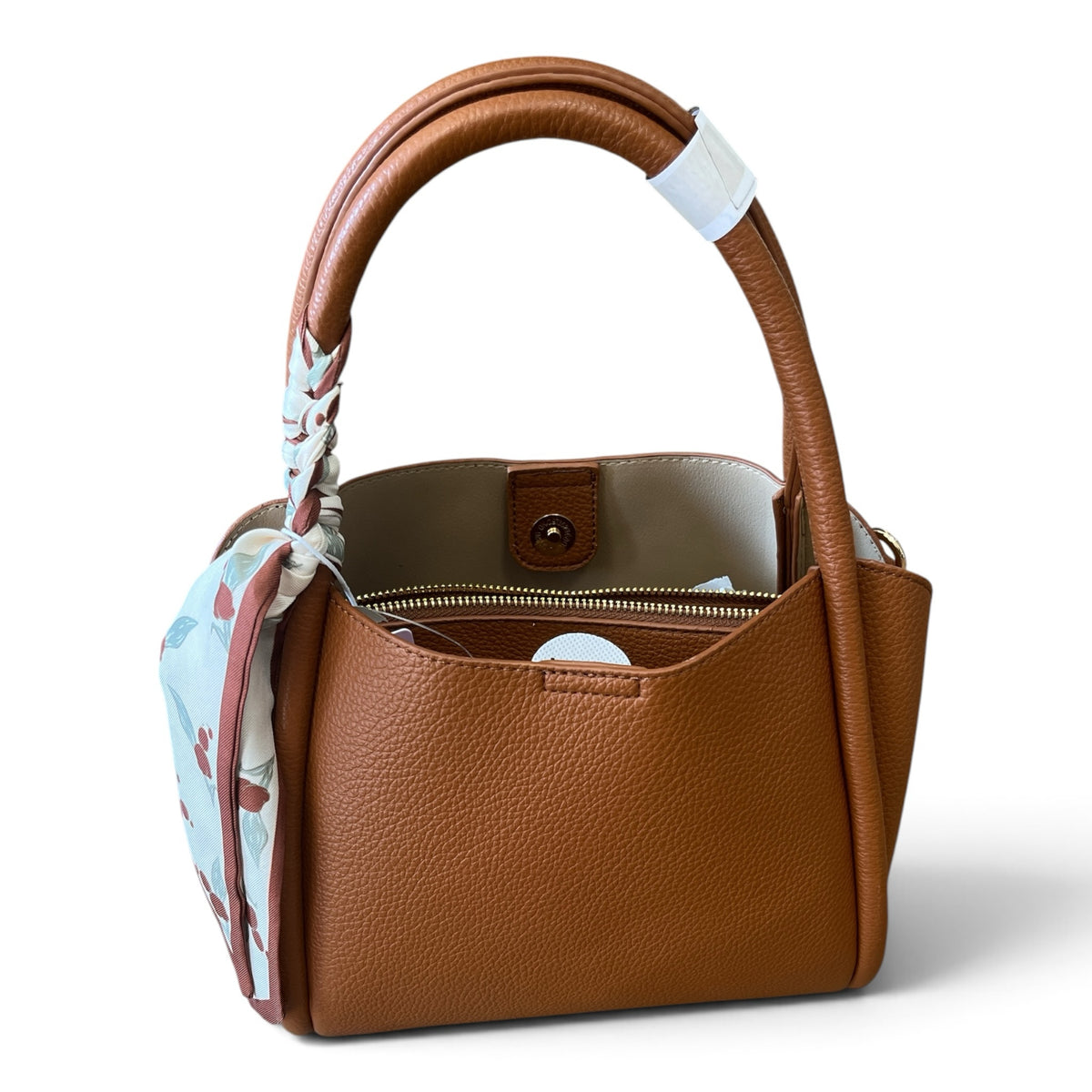 Superlative Online tan pebble-grain faux leather handbag with a floral scarf tied to the handle and magnetic closure.